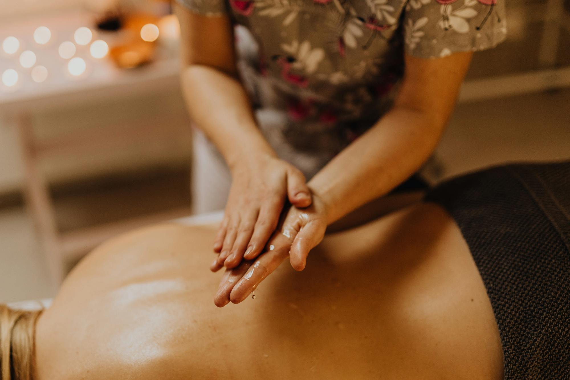 Therapist giving an oil massage in candlelight